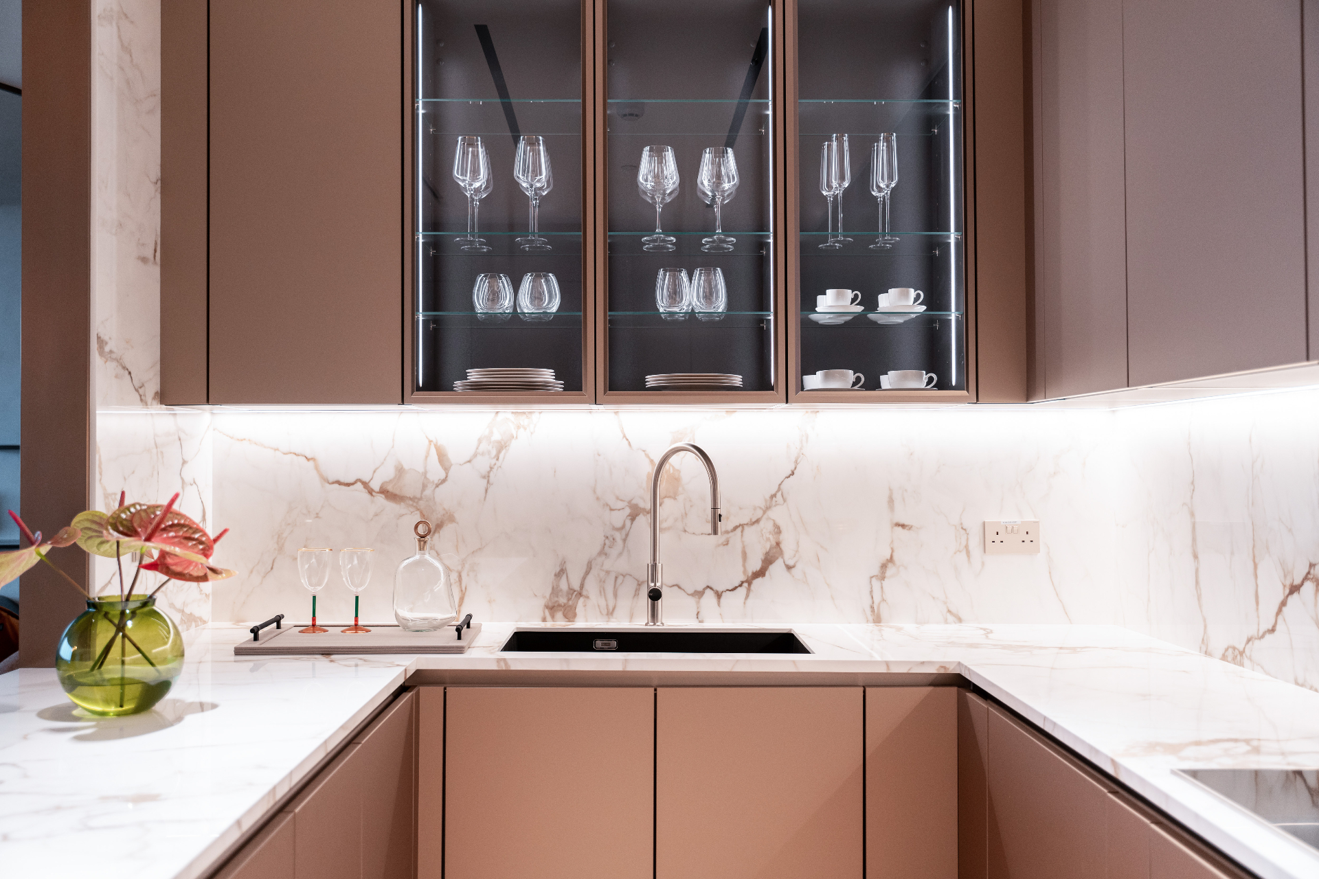 Bespoke kitchen with marble countertops and illuminated glass cabinetry